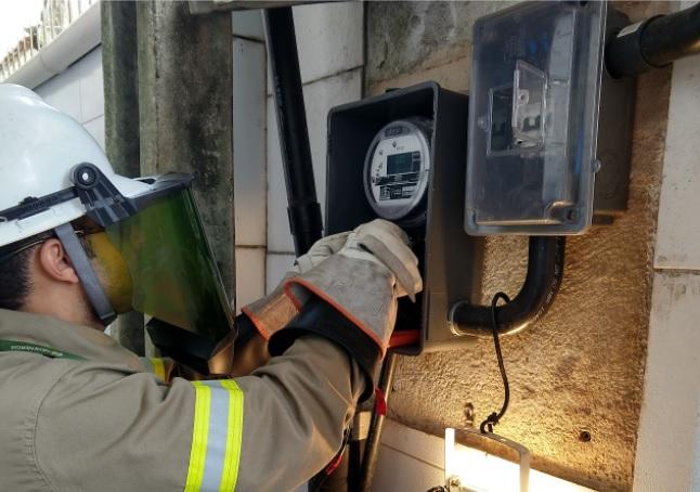 Trabalhador com EPI manuseando relógio elétrico