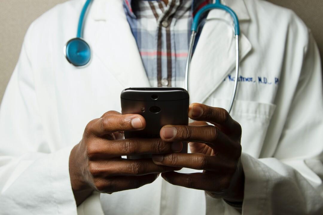Médico utilizando aparelho celular