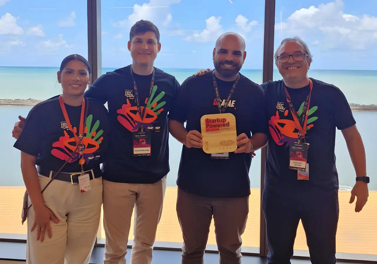 Startup Gravae utiliza IA e Visão Computacional no esporte Quatro profissionais sorridentes, três com t-shirts do festival REC'n'Play, seguram o troféu Startup Powered by CESAR.