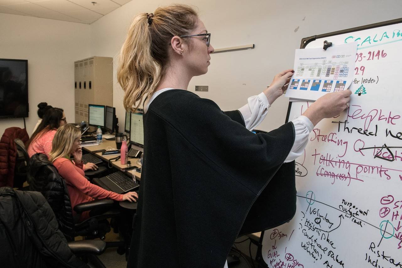 Mulher loira fazendo anotações no quadro branco